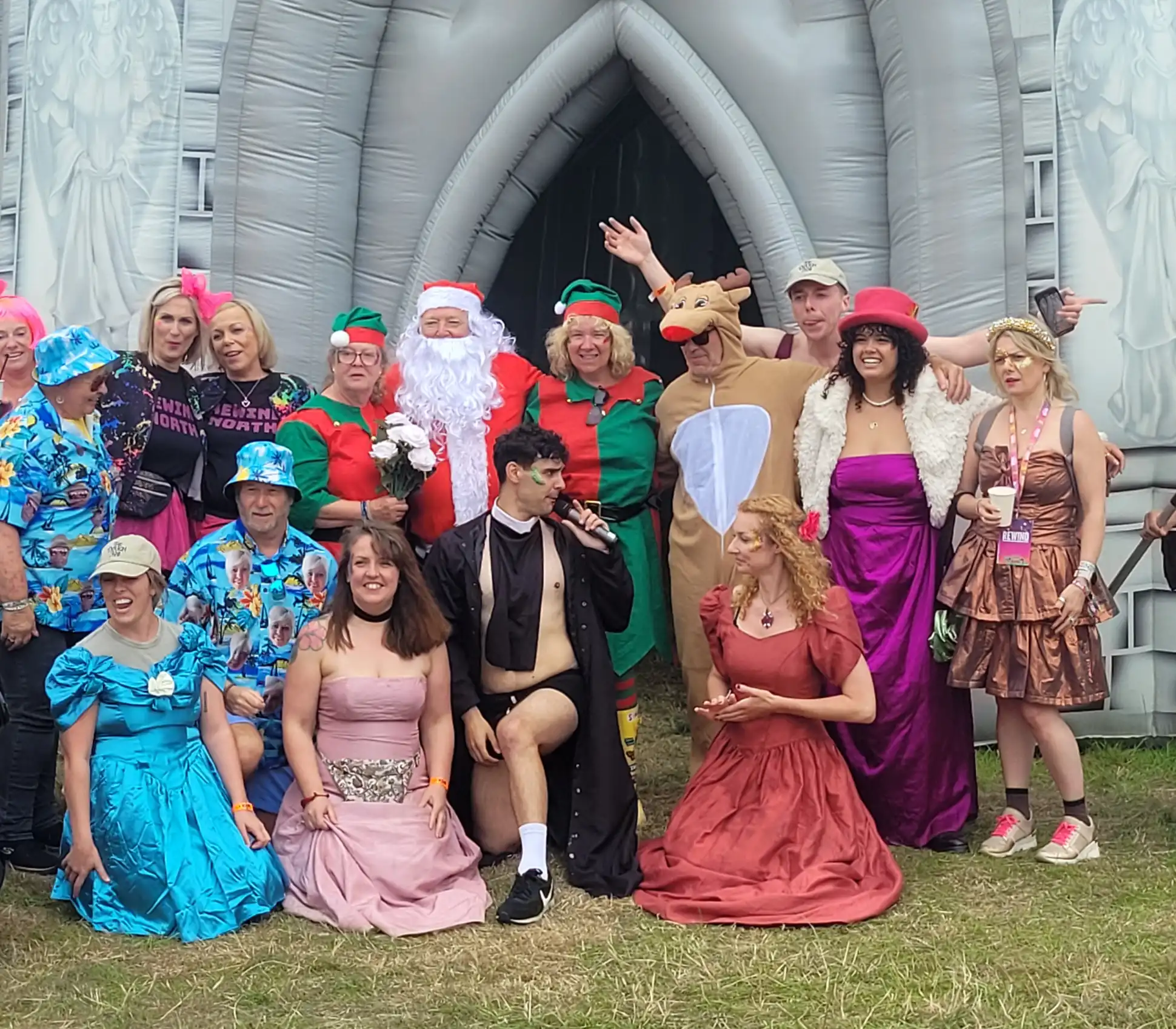 Festival goers in fancy dress posing by the castle attraction at Rewind Festival North 2024