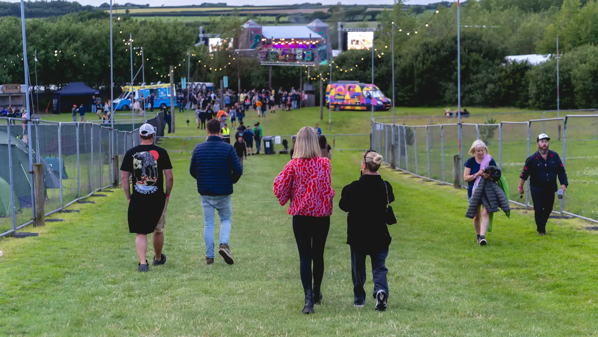 The Wyldes 2024 - crowds walking on site with fairy lights in the distance