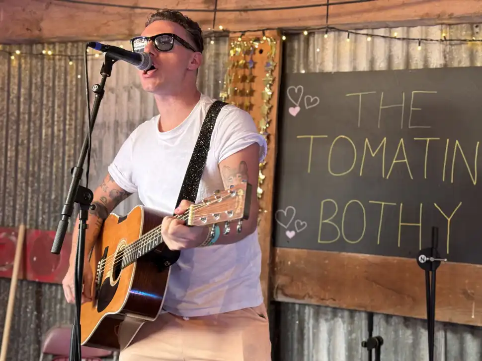 Callum Beattie plays a surprise set at Tomatin Bothy strumming an acoustic guitar while wearing sunglasses