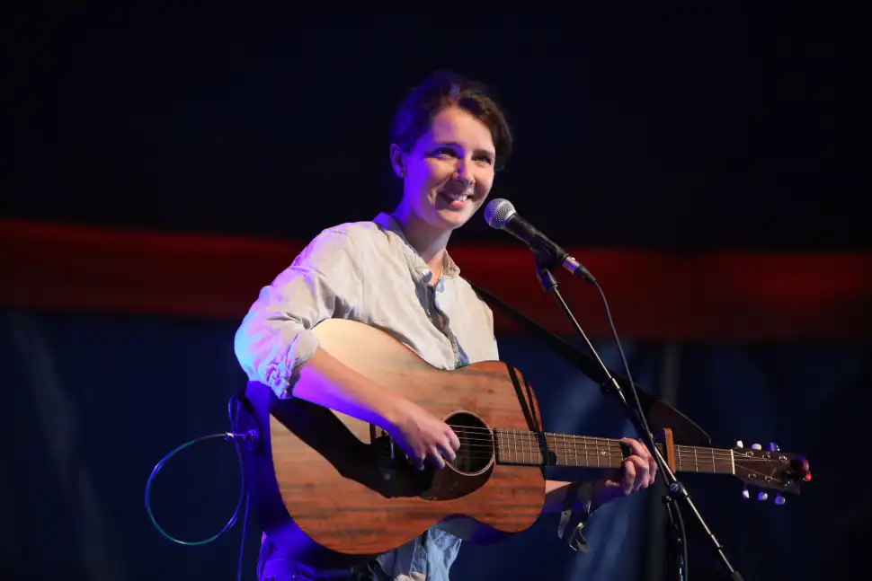 Roseanne Reid plays acoustic guitar and smiles