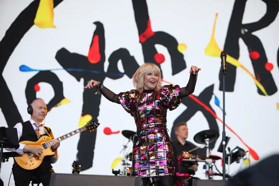 Toyah smiles at the audience while Robert plays electric guitar and looks on