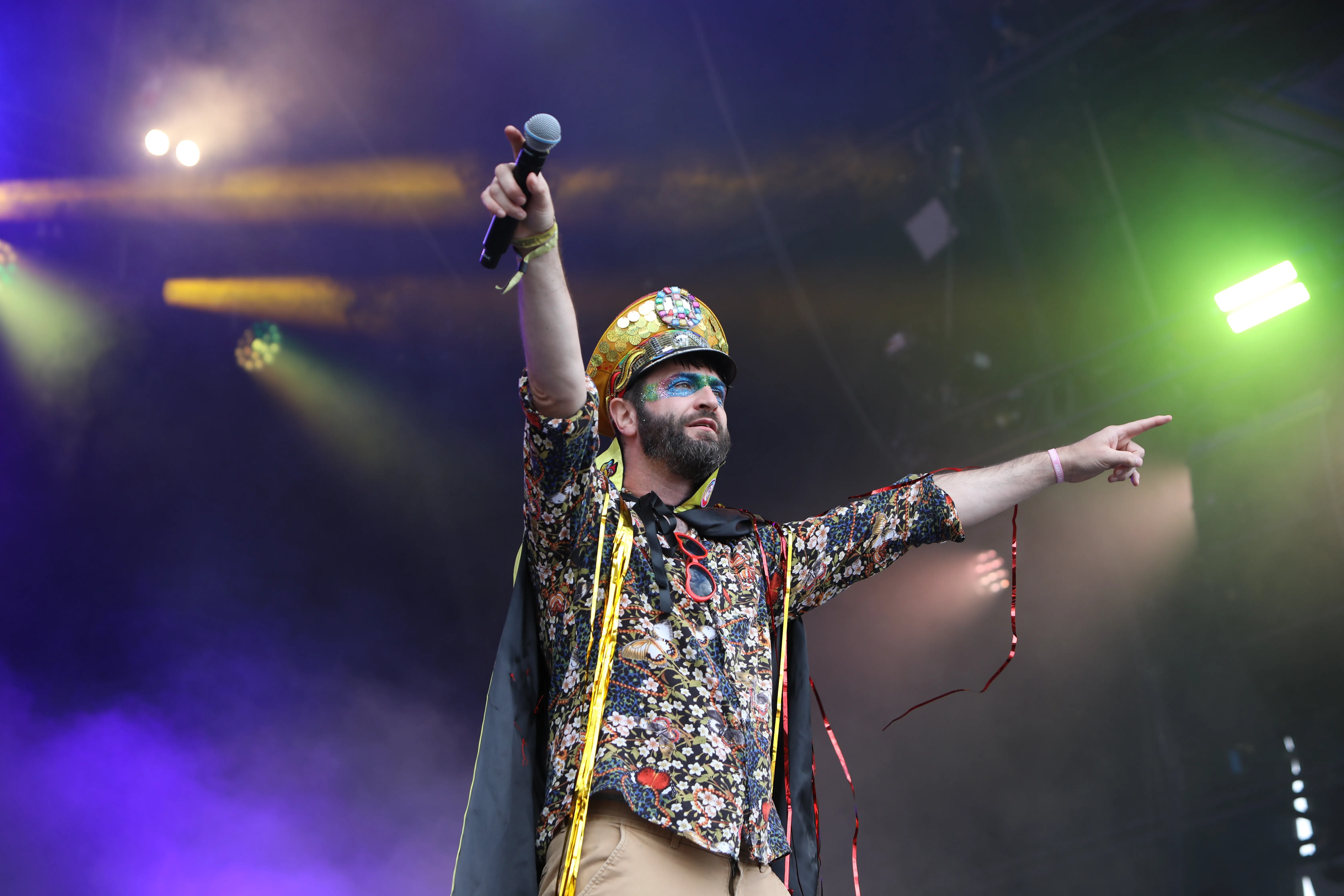 Colonel Mustard And The Dijon 5's frontman wearing lots of colour with a peace-sign hat and sparkly face paint