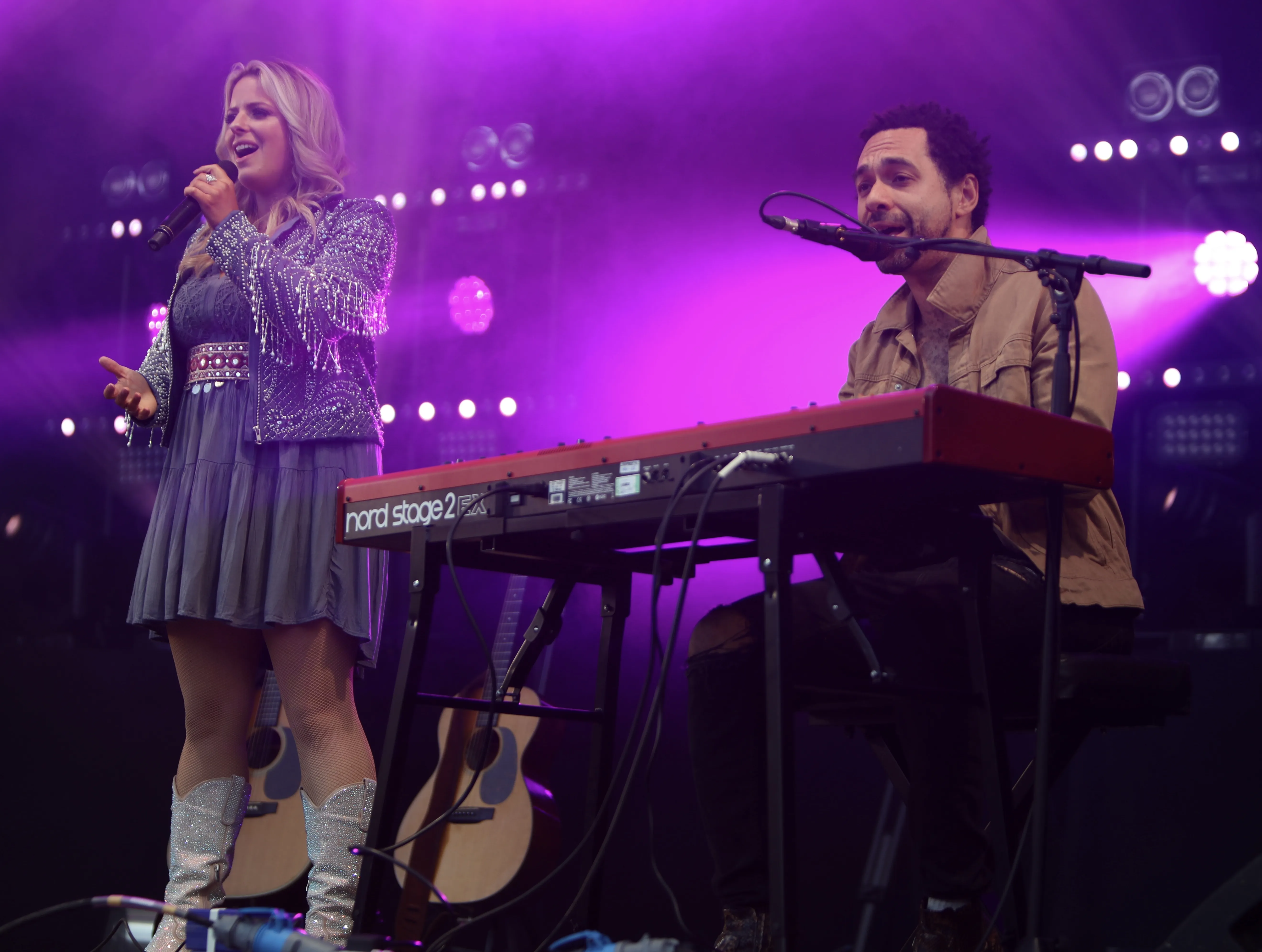 Crissie Rhodes sings wearing sparkly cowboy boots while Ben Earle plays a keyboard