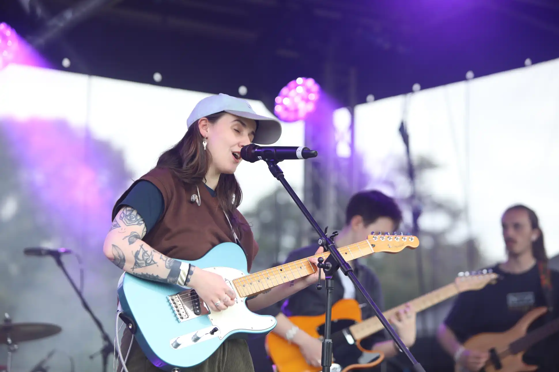 Heartland Festival In Pitlochry 2024 - Sara Rae on stage singing and playing a blue guitar