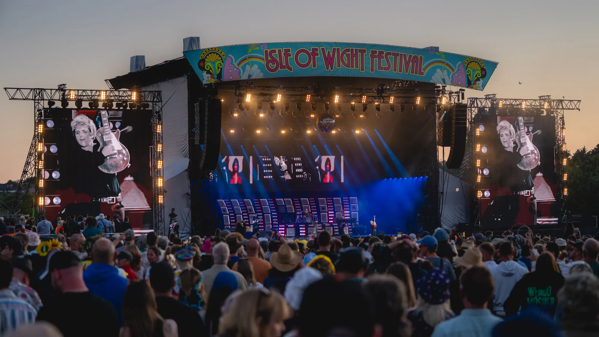 Green Day headlining the Isle of Wight Festival 2024 pictured from a distance on the main stage at dusk